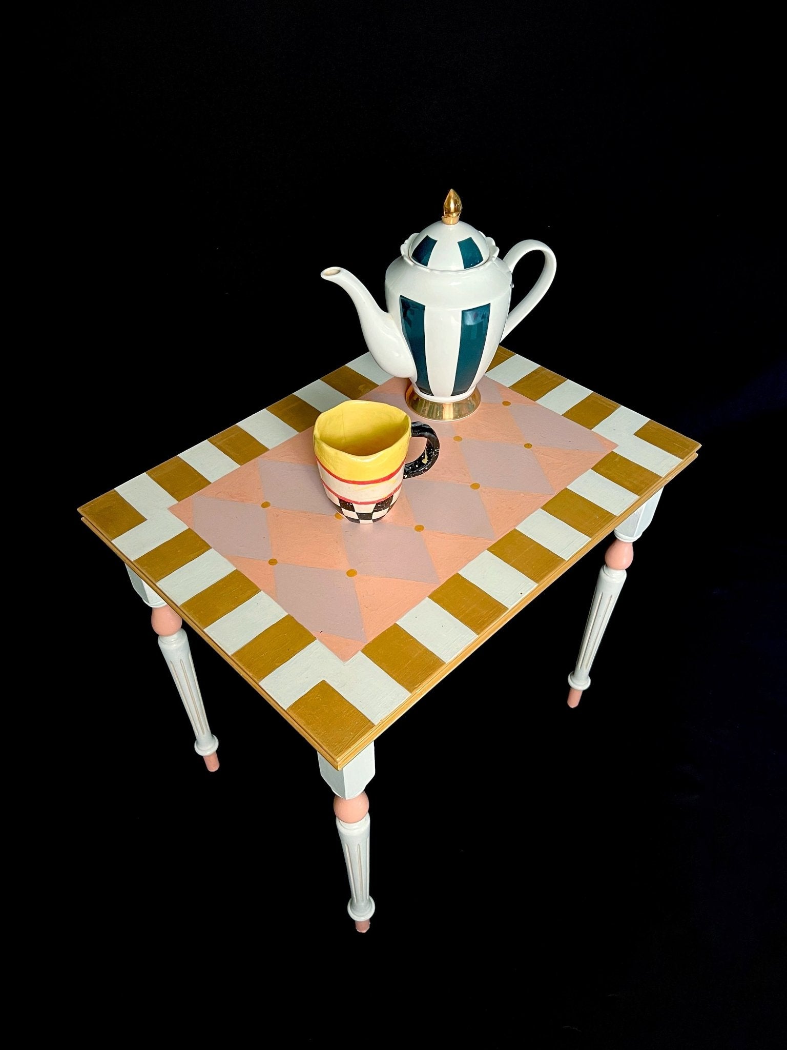 Mesita artesanal infantil «La Merienda del Espejoverso» con tetera y taza en colores vivos sobre fondo negro